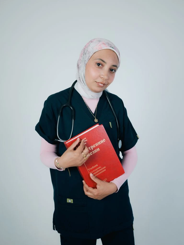 A board-certified U.S. physician in a white coat reviewing an online consult at a neutral desk.